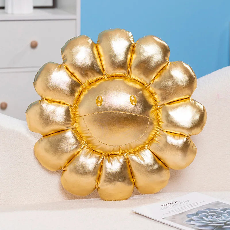 A large, golden sunflower plush cushion designed as a soft floor pillow with a cheerful face.