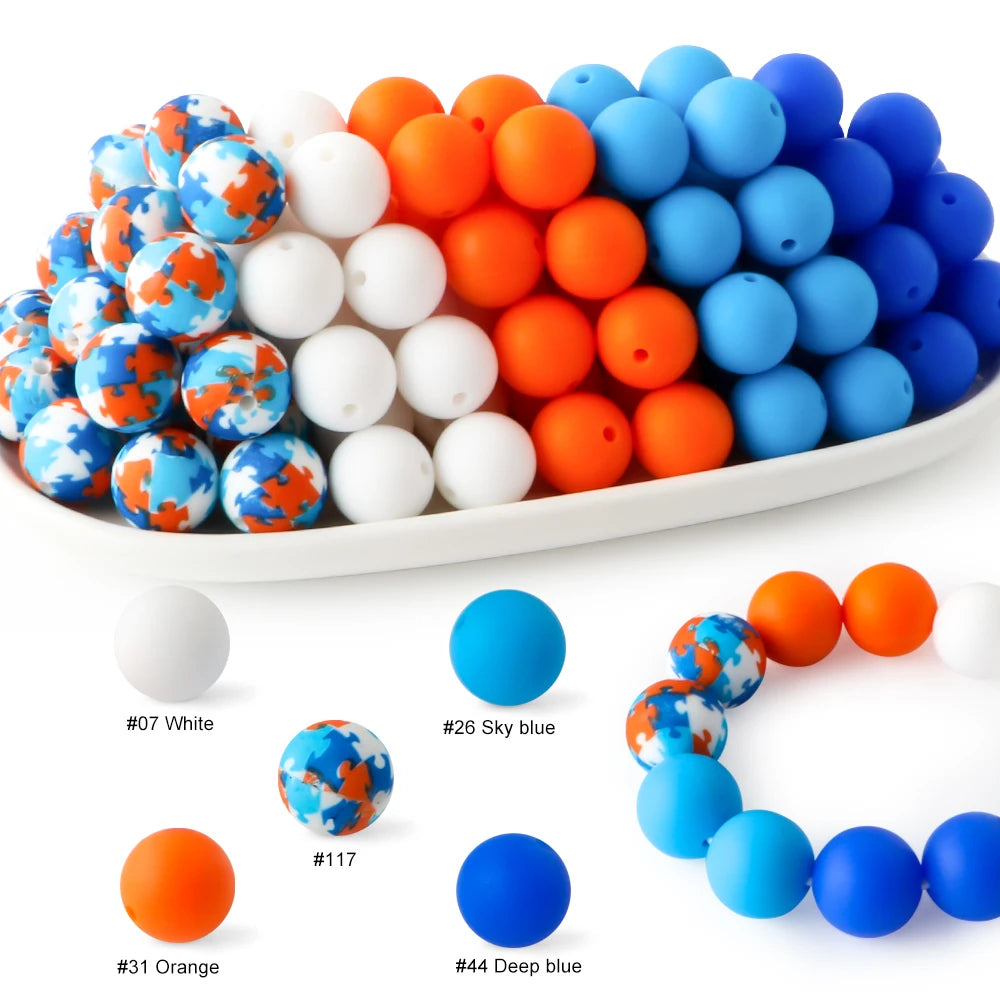 A collection of soft food-grade silicone beads in various colors including white, orange, and blue arranged in a line.