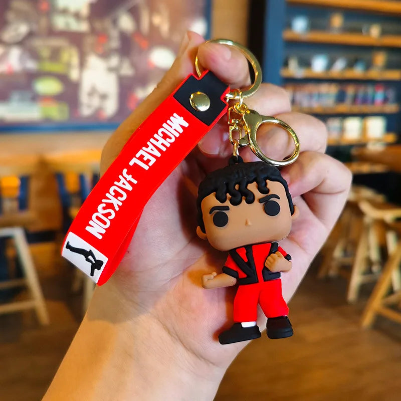 A keychain featuring a figurine of Michael Jackson in a dance pose, with a red tag attached.