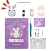 A purple pouch containing a Woobles learn to crochet kit for beginners, including yarn and tools.