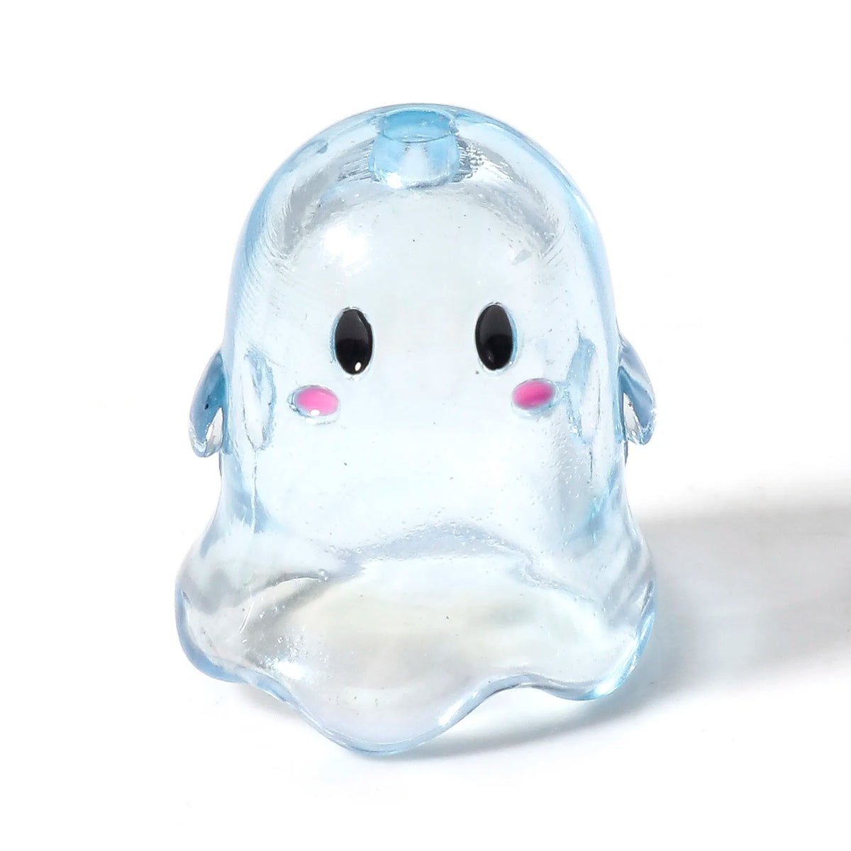 A translucent light blue acrylic ghost bead with black eyes and pink accents.