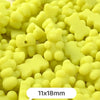 A close-up view of yellow bear-shaped acrylic craft beads with a shimmer finish