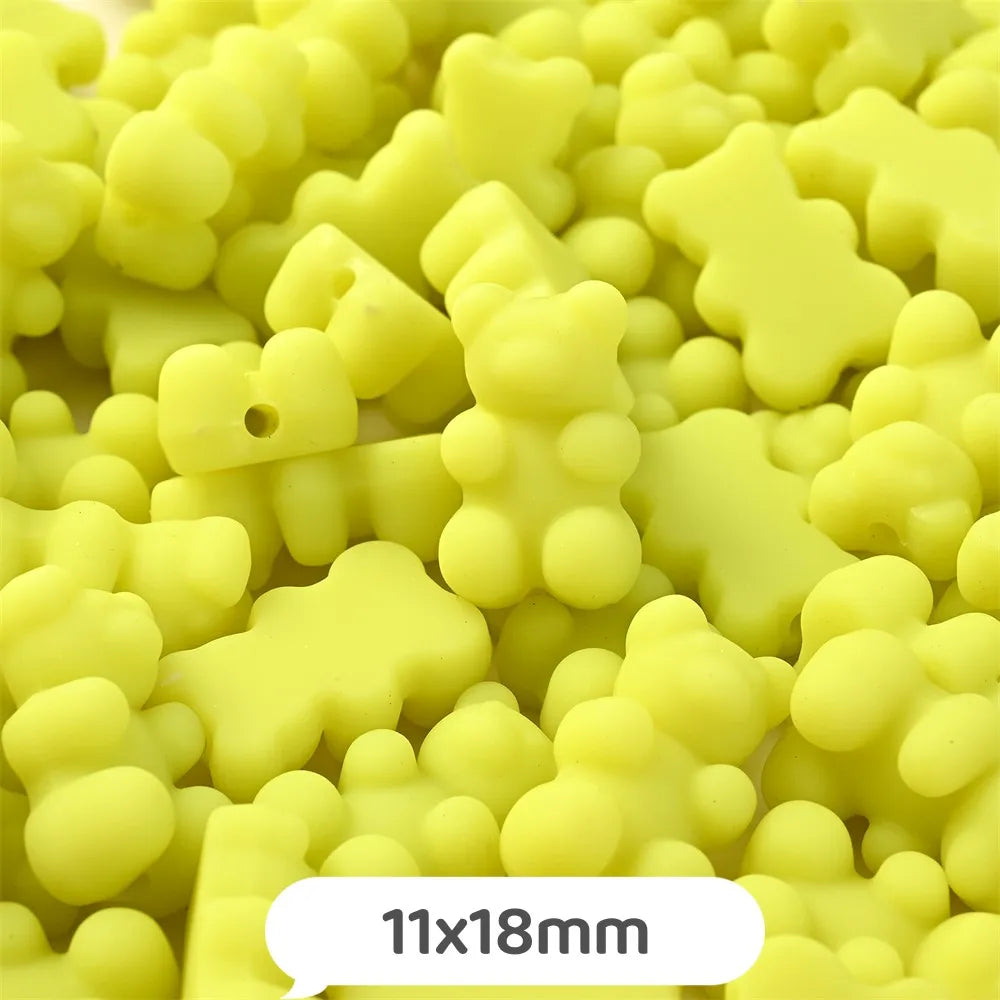 A close-up view of yellow bear-shaped acrylic craft beads with a shimmer finish