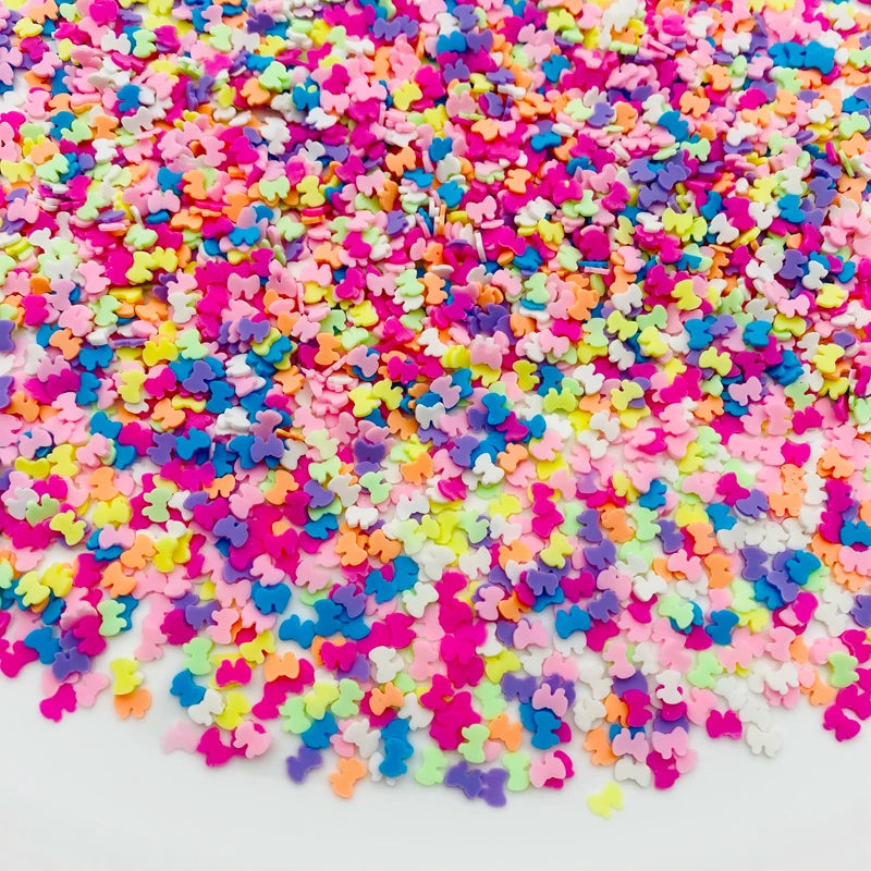 A pile of colorful polymer clay star and heart sprinkles in various bright colors.