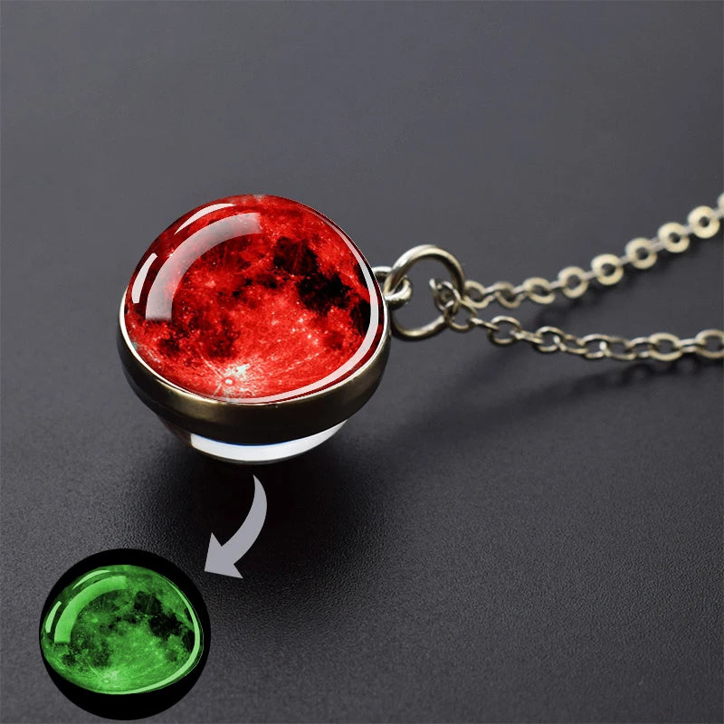 A pendant necklace featuring a red, glowing celestial body, with an inset showing a green celestial body.