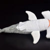 A white and gray plush toy of a hammerhead shark with fins and a tail.