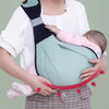A woman is holding an adjustable cotton ring sling baby carrier with a light green fabric and black straps.