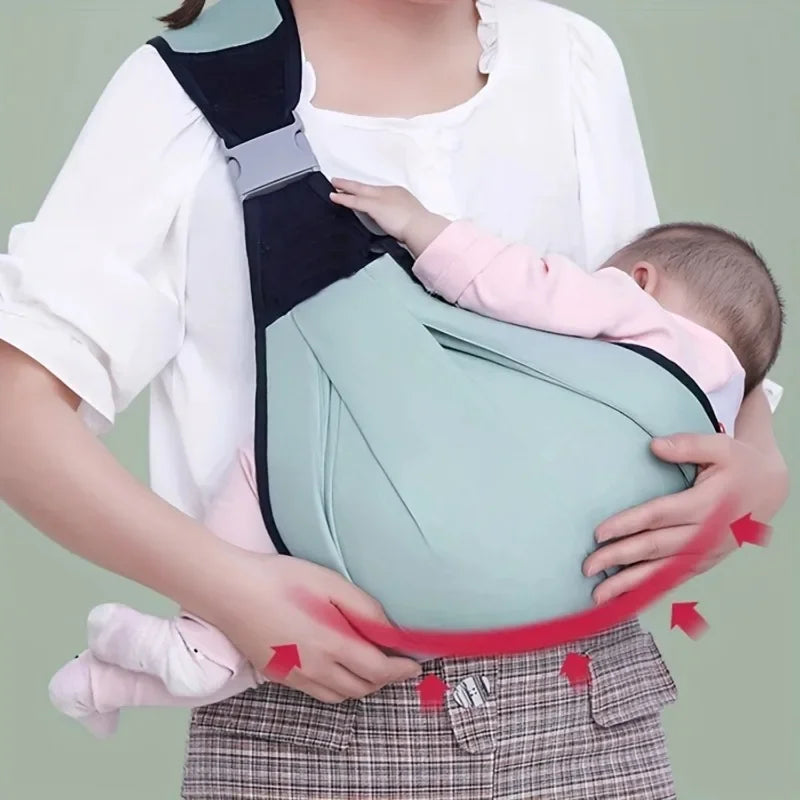 A woman is holding an adjustable cotton ring sling baby carrier with a light green fabric and black straps.