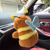 An orange capybara plush toy with yellow stripes and light blue wings attached to a gold keychain.