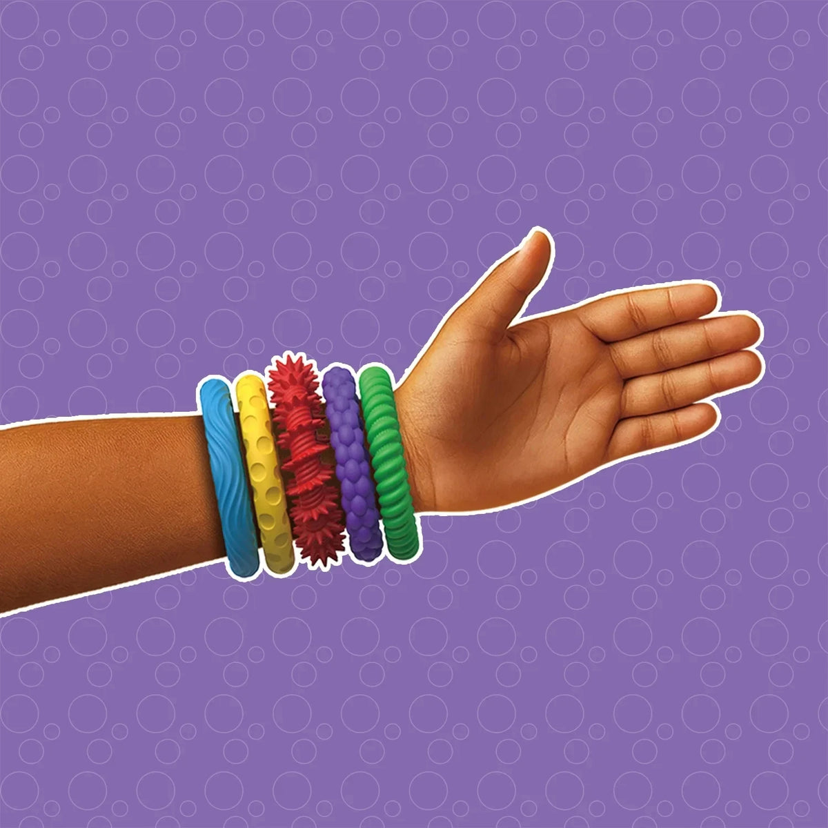 A hand is shown with several colorful sensory fidget bracelets stacked on the wrist against a purple background.