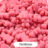 A pile of pink bear-shaped acrylic craft beads with a shimmer finish.