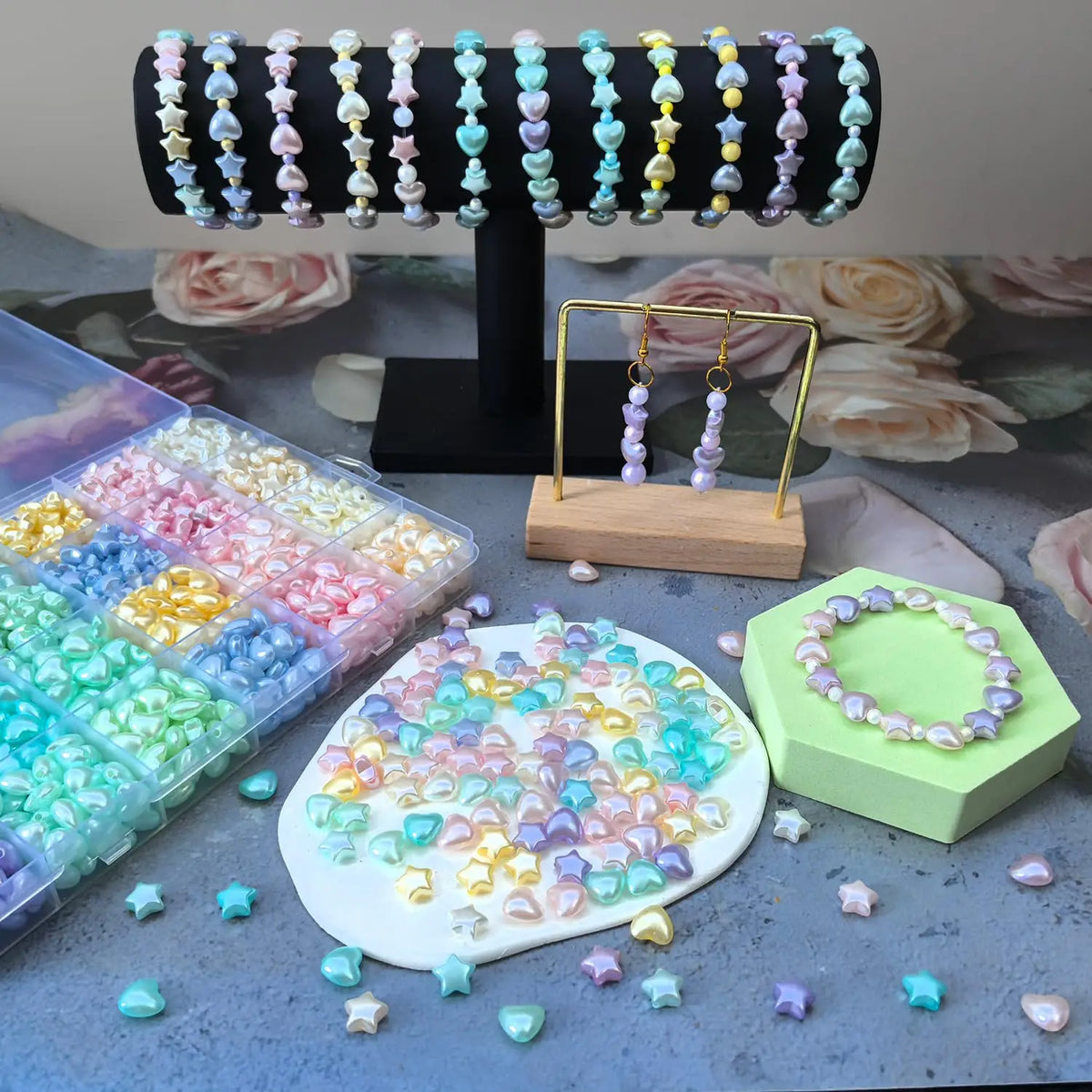 A display of various frosted golden foil acrylic beads in pastel colors and shades, some arranged on a wooden stand.