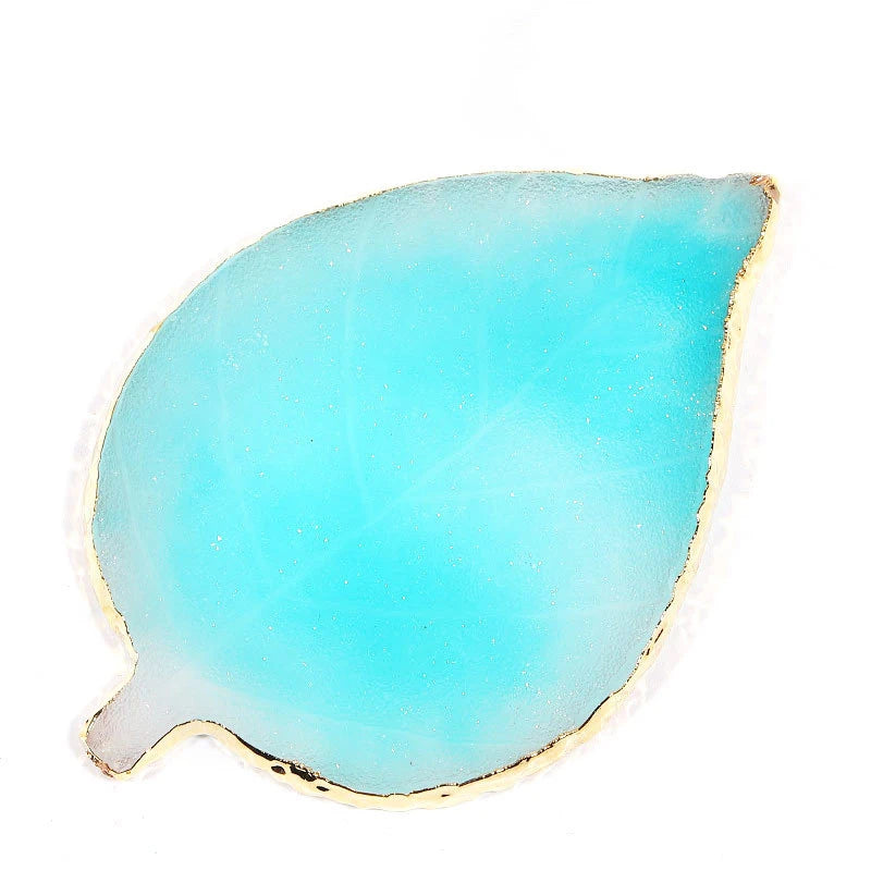 A translucent turquoise resin nail art palette with a gold trim.
