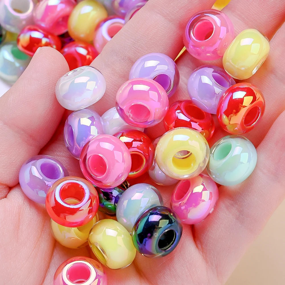 Une main tient une collection de perles de séparation en acrylique facettées colorées pour la fabrication de bijoux DIY