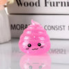 A bright pink glitter squishy stress ball shaped like a smiling face, resting on a reflective surface.