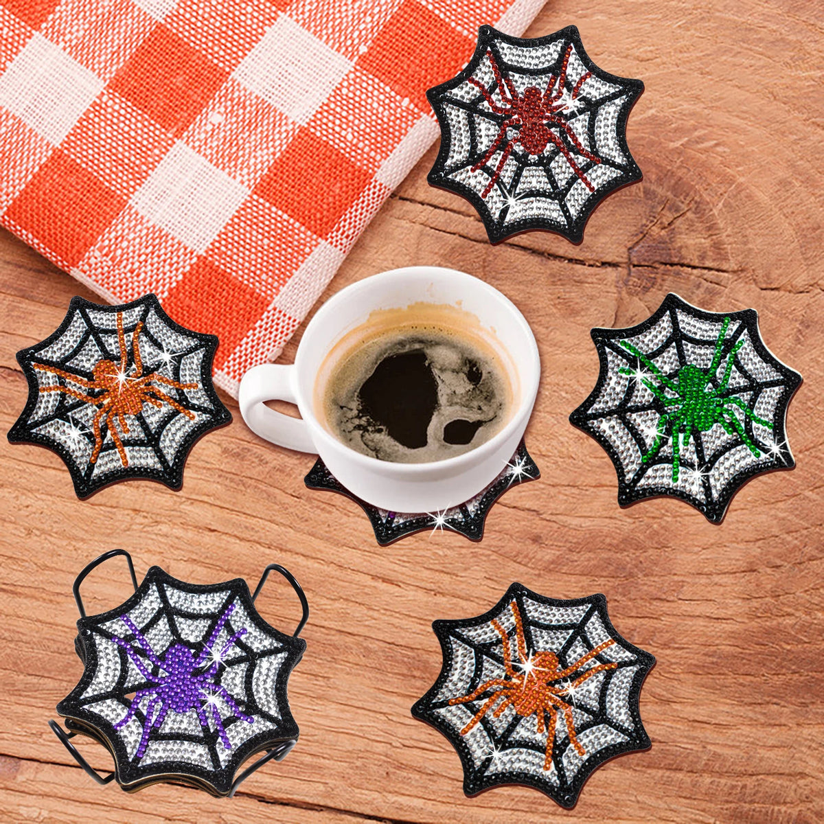 A collection of nine DIY diamond art coasters featuring various spider web designs in black, orange, white, and green.