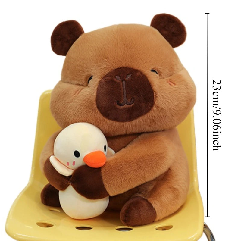 A brown capybara plush toy mother holding four small white baby plush toys.