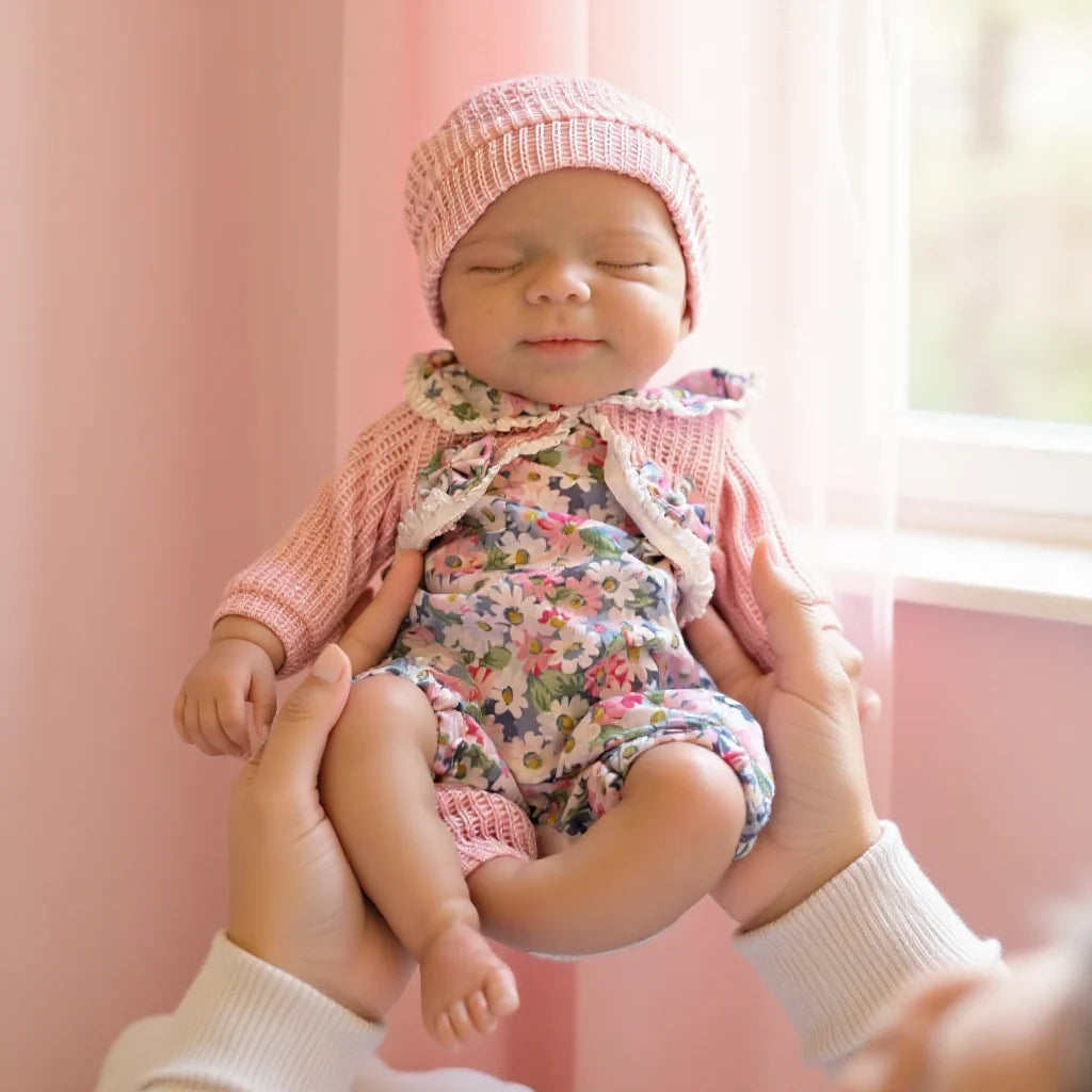 A newborn baby wearing a pink knitted hat and floral romper is being held by a person near a window.