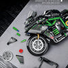 A detailed close-up of a Kawasaki motorcycle model kit and related parts laid out on a gray surface.