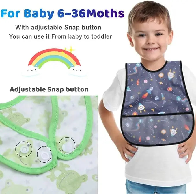A smiling toddler wearing a dark blue and purple cartoon-patterned baby bib on a white shirt.