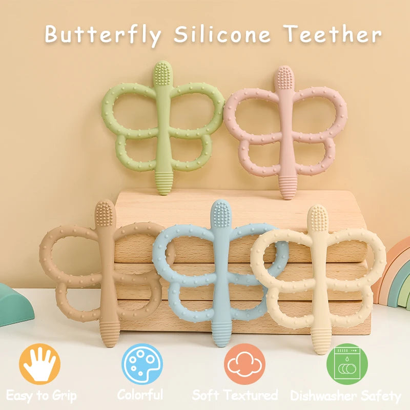 A set of soft silicone butterfly teethers in various pastel colors resting on a wooden surface.