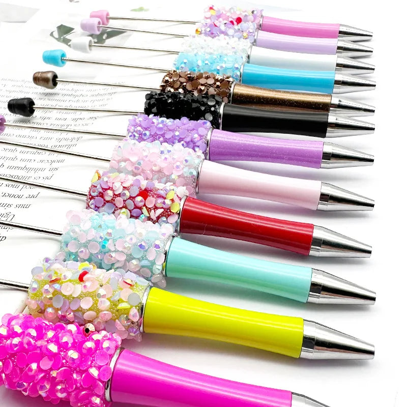 A collection of 12 ballpoint pens filled with various colors and textures of diamond sequins.