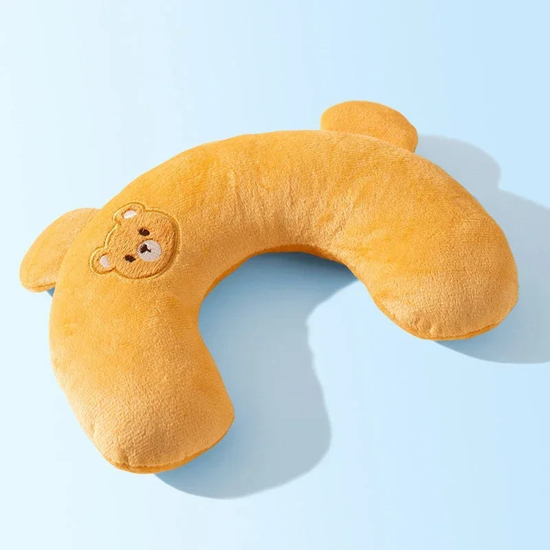 A fluffy orange U-shaped plush pillow shaped like a bear for neck support.