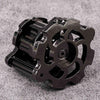 A black revolver-shaped metal dice set for RPG games resting on a gray surface.
