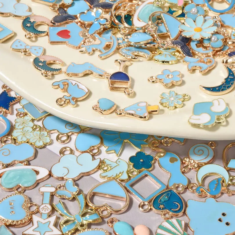 Assorted metal pendants and charms in gold and blue enamel for jewelry making