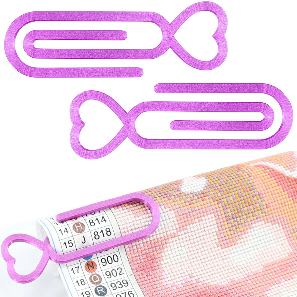 A set of two purple heart-shaped clips used for diamond painting canvas
