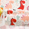 Fabric print featuring pink and red dinosaurs on a white background for sewing and DIY crafts