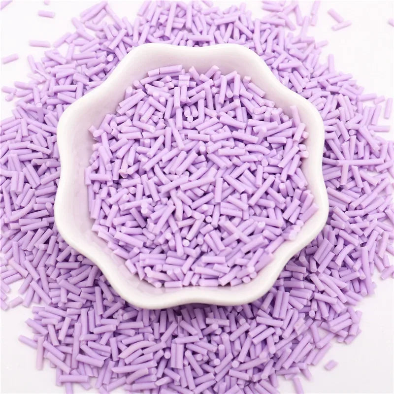 Purple polymer clay slice sprinkles scattered on a white background, with some forming a decorative mound.