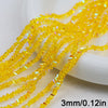 Yellow crystal triangle beads strung on a string and displayed next to a white object.