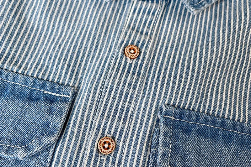 A close-up of a blue and white striped denim jacket with button details.