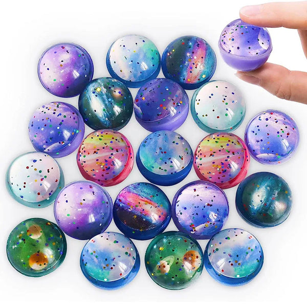 A collection of assorted, brightly colored rubber bouncy balls in various iridescent and glitter finishes.