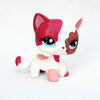 A small figurine of a kitten with white and pink fur and sparkly red eyes.
