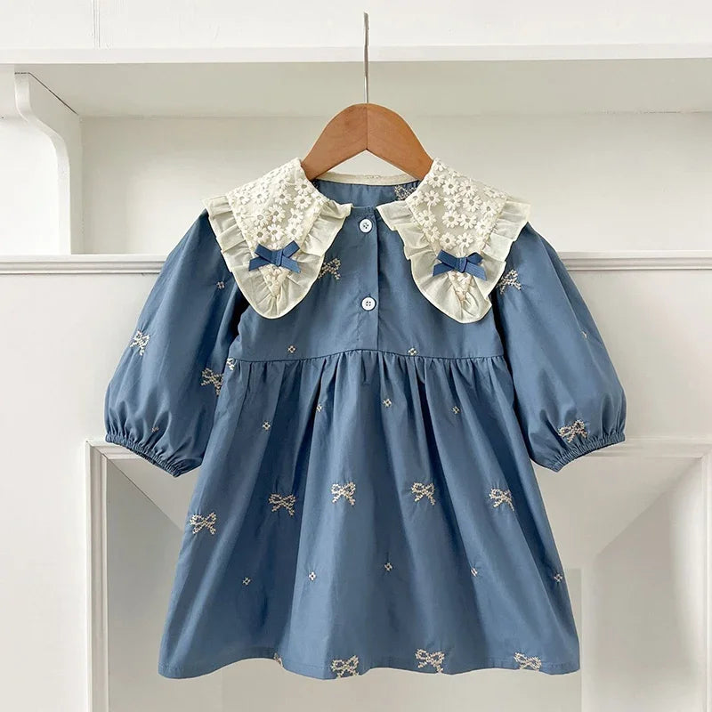 A light blue cotton party dress for girls featuring lace collar details and embroidered accents.