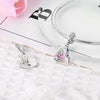 A silver heart charm for bracelets and necklaces is displayed next to a silver chain on a white surface.