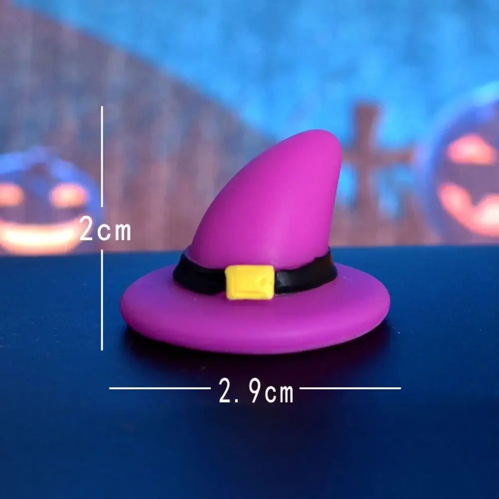 A purple witch hat with a yellow band and a small pumpkin decoration, shown against a blue background.