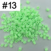 A pile of 1000 small, green plastic fuse beads for creative craft projects.