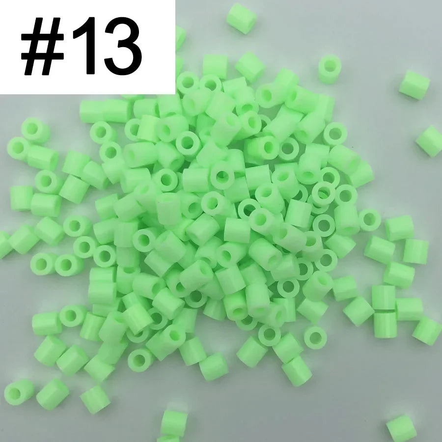 A pile of 1000 small, green plastic fuse beads for creative craft projects.
