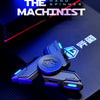A close-up of a blue metal luminous fidget spinner resting on a dark surface with the title The Machinist visible in the back