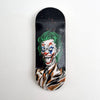 A black wooden fingerboard deck featuring a UV-printed graphic of the Joker face.