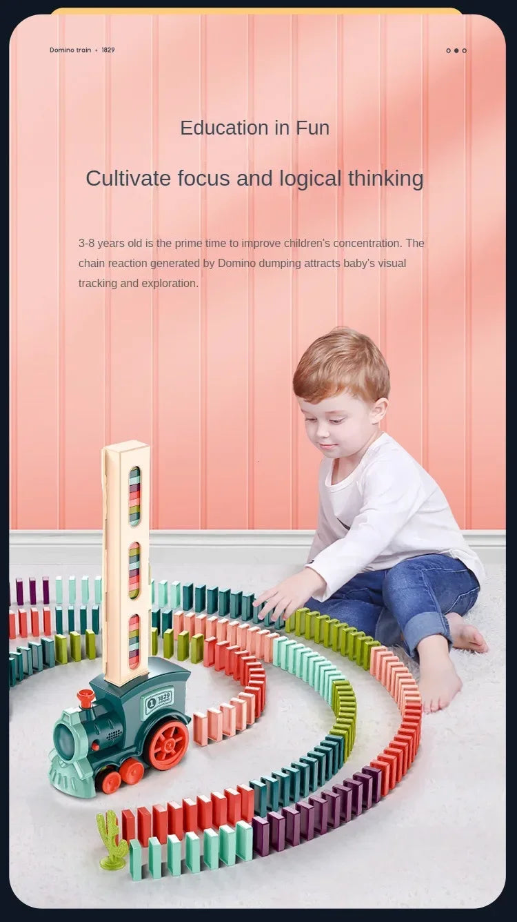 A young boy is playing with an automatic domino train toy made of colorful building blocks on a white floor.