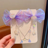 A set of purple and iridescent pearl butterfly hair clips for girls displayed on a white card.
