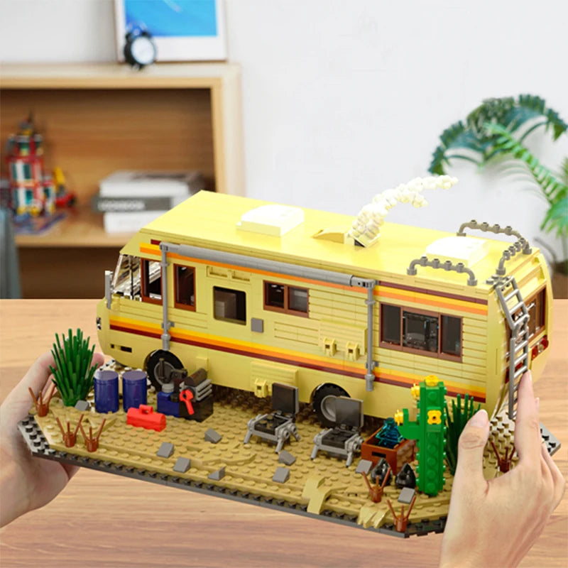 A building block set depicting a yellow RV camper bus with various outdoor elements and accessories.