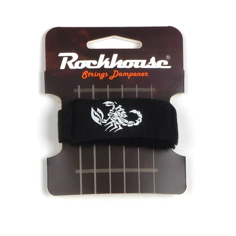 A black guitar string dampener is shown packaged on a brown cardboard backing.