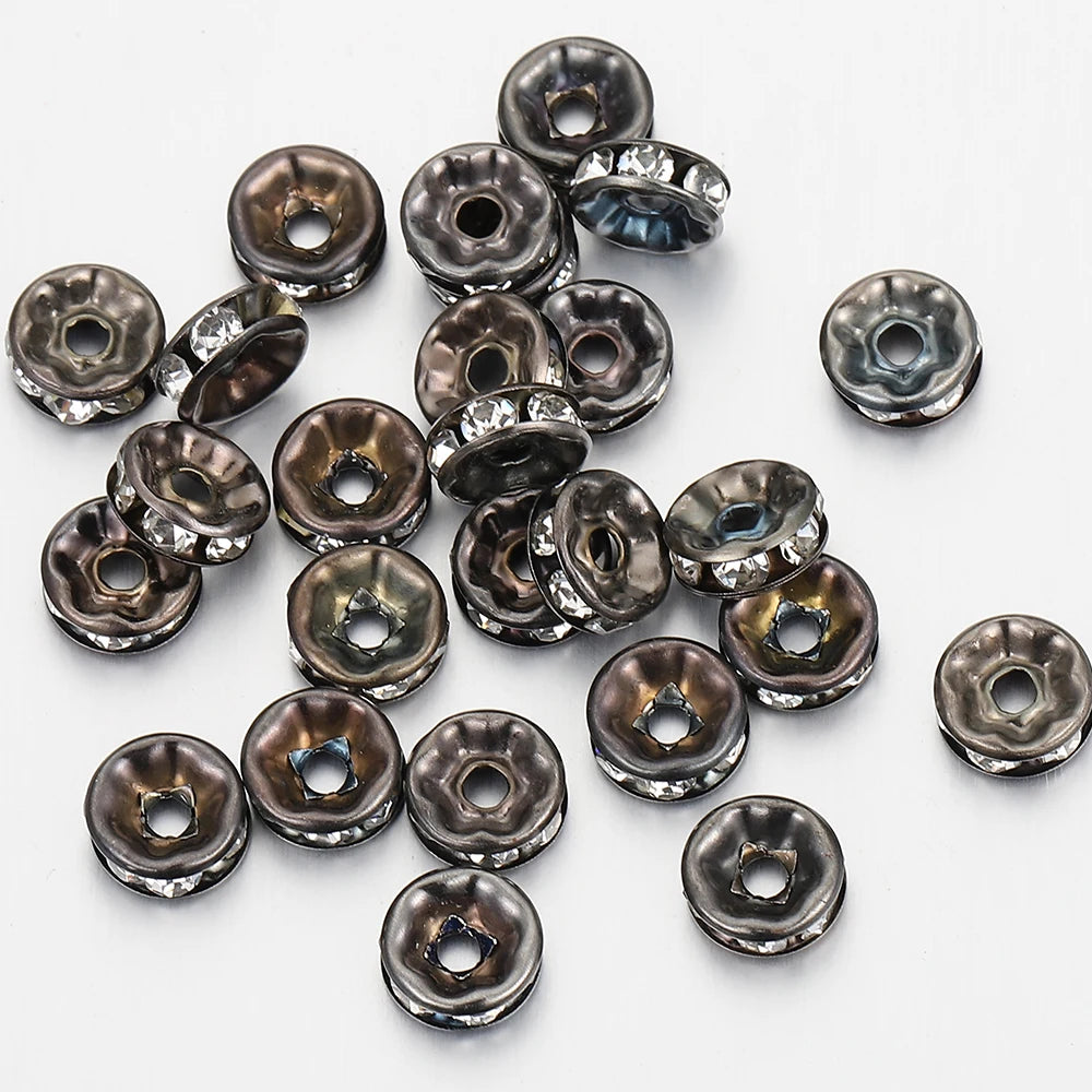 A collection of silver-toned crystal rondelle spacer beads for jewelry making, shown from above.
