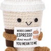 A handmade crochet plush toy resembling a cup with a positive message about espresso