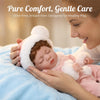A woman gently holds a baby wearing a white fuzzy winter hat and pink outfit on a blue blanket.